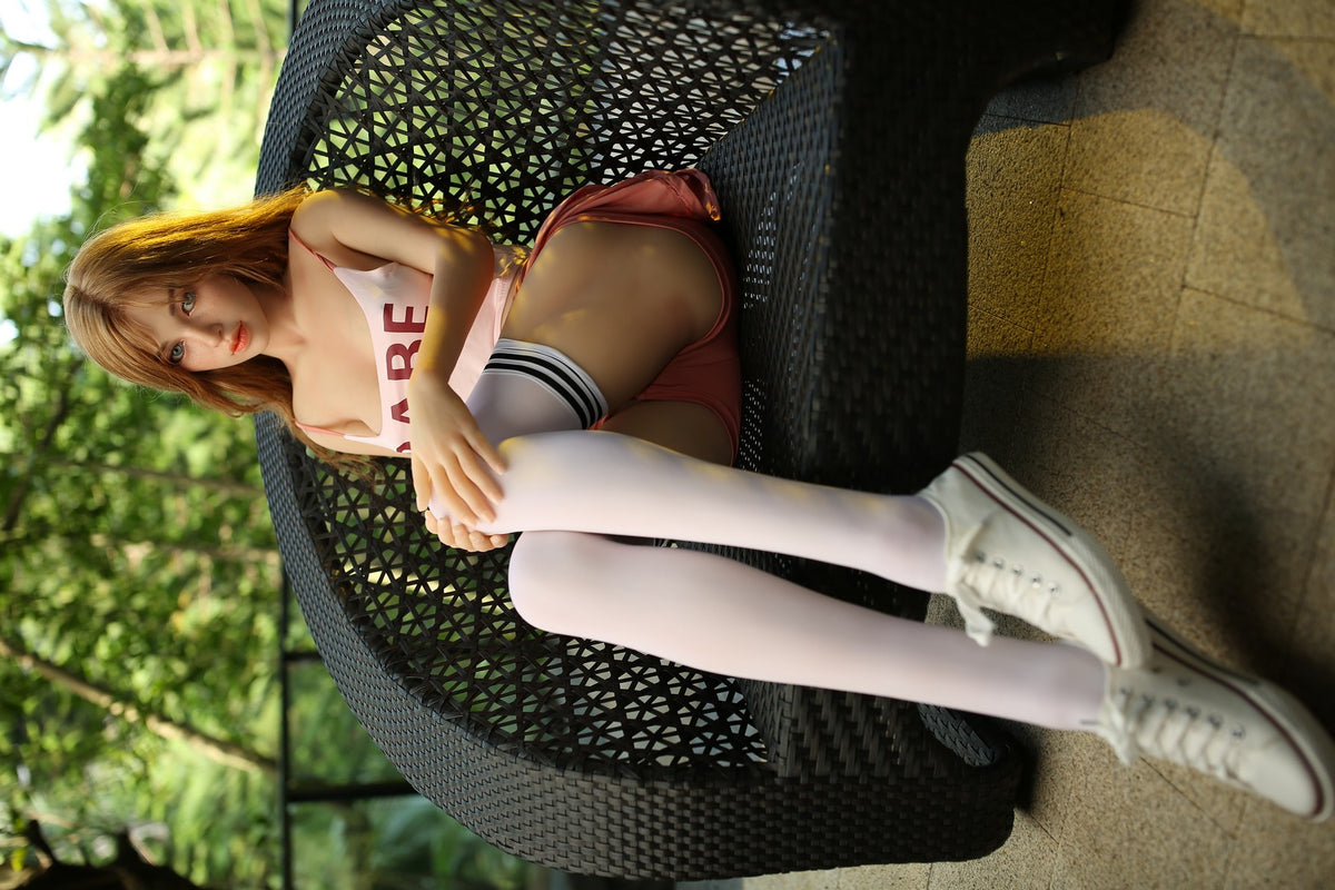 Iris seated in a woven chair with her hands folded