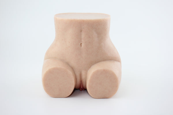 Upright front view of peach-shaped silicone lower torso