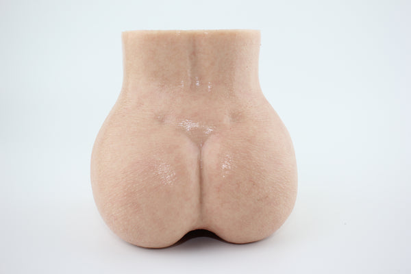 Upright rear view of peach-shaped silicone torso