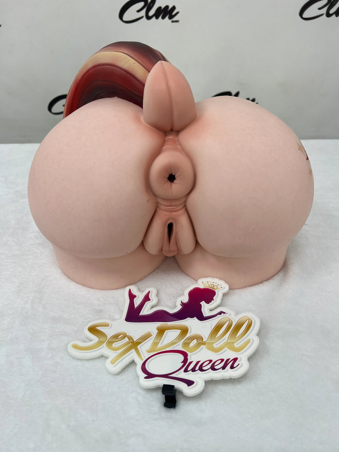 A front-facing shot of a silicone torso featuring a small ponytail-like appendage.