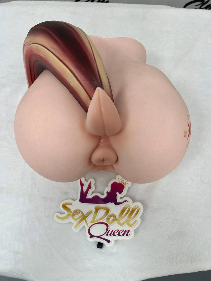 A silicone torso featuring a small, ponytail-like appendage, captured in a top-down shot to showcase its shape from an overhead perspective.