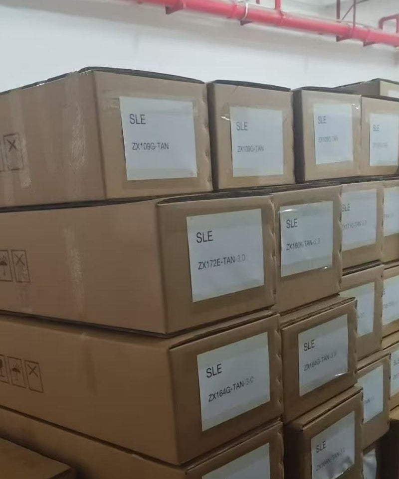 Stacks of brown cardboard boxes labeled SLE with product codes, stored in a warehouse setting.