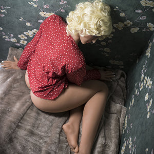 a woman laying on a bed with a teddy bear 